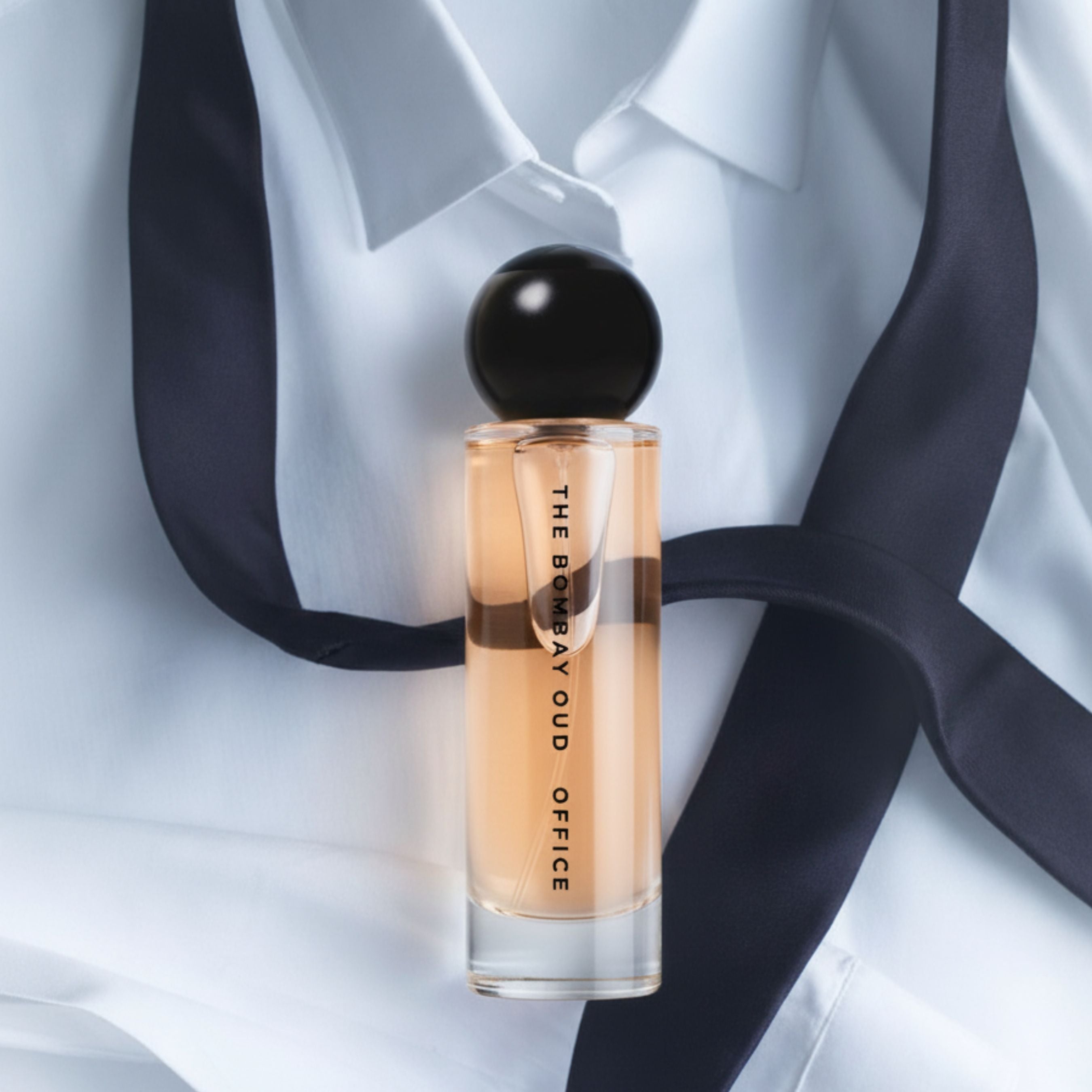 Office 60ml perfume by The Bombay Oud placed on a crisp white shirt with a navy tie, symbolizing elegance and professional charm.