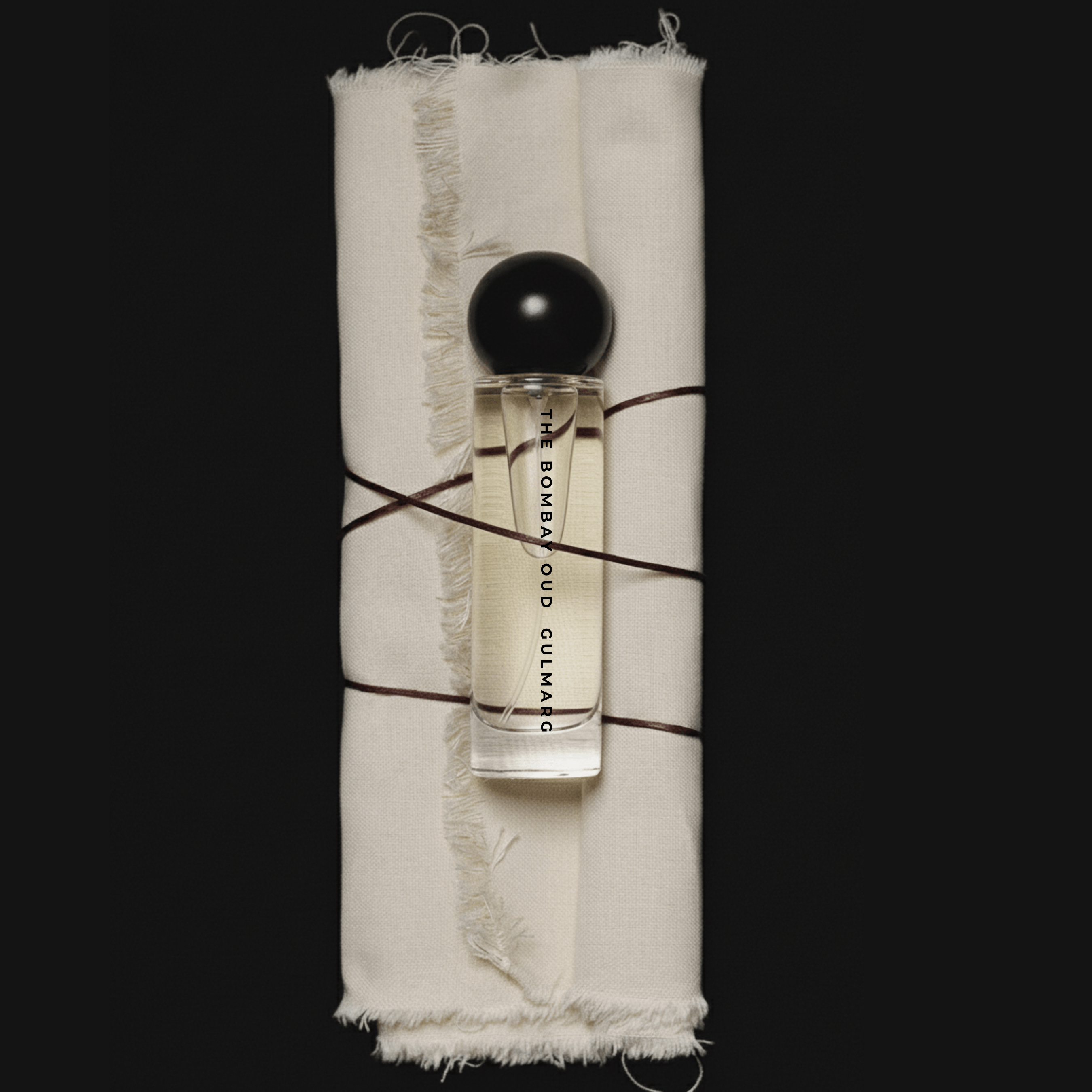 Gulmarg 60ml fragrance bottle wrapped in raw fabric and twine, highlighting artisanal and nature-inspired luxury packaging.