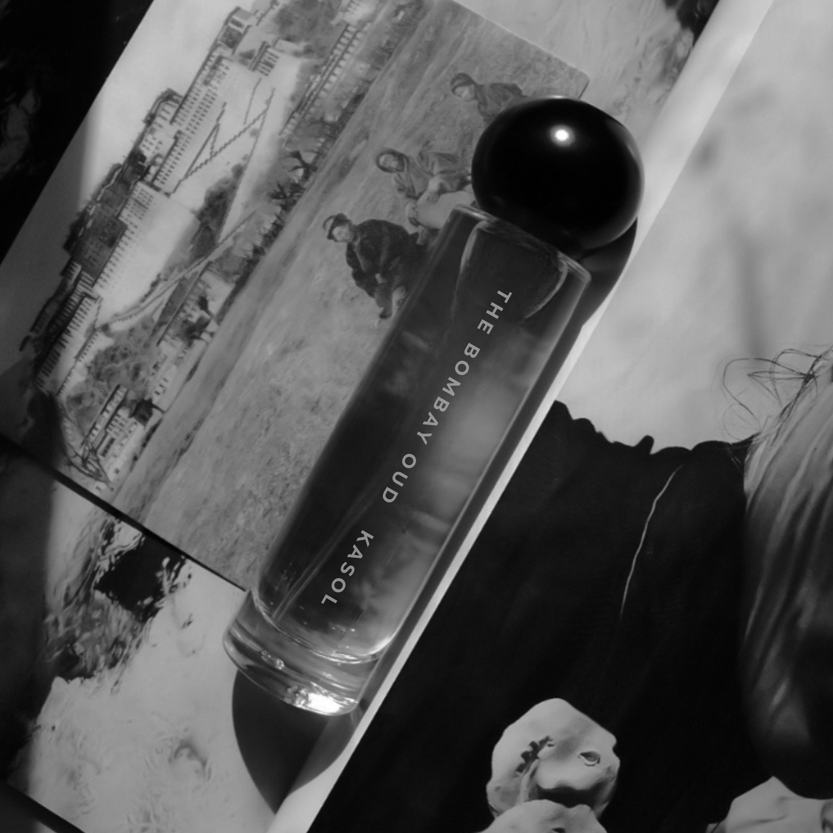 Kasol 60ml fragrance bottle in monochrome, placed on vintage-style photographs, highlighting its nostalgic and artistic appeal.