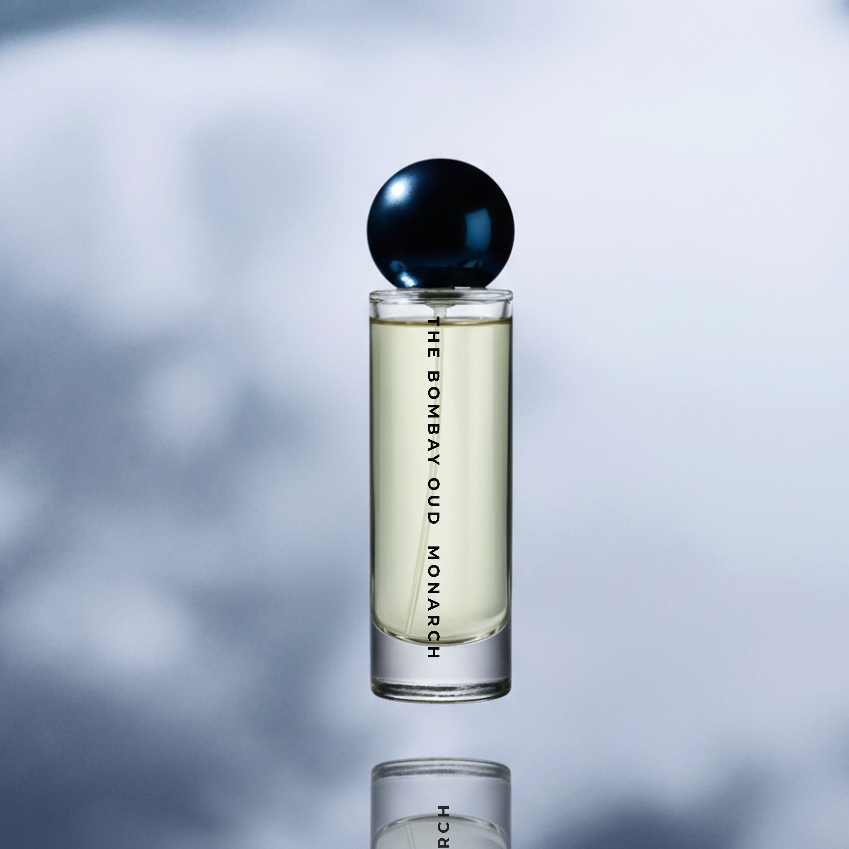 Monarch 60ml eau de parfum standing upright with a reflective sky background, emphasizing its clean and elegant presentation.