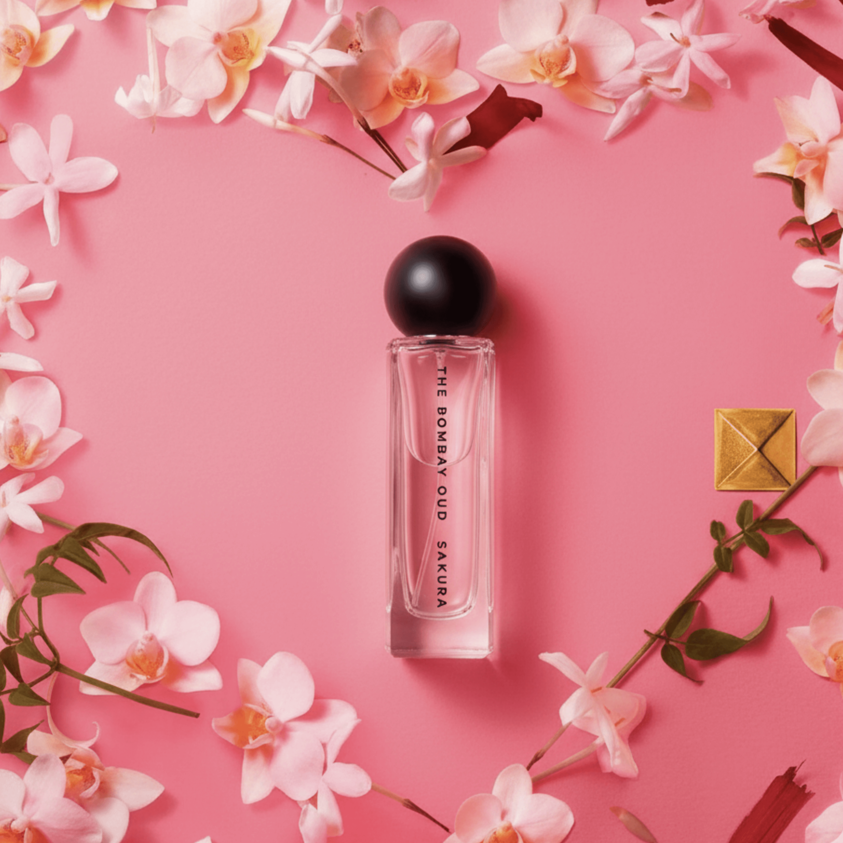 sakura 60ml eau de parfum bottle surrounded by pink orchids and cherry blossoms on a pastel pink background, ideal for floral fragrance lovers.