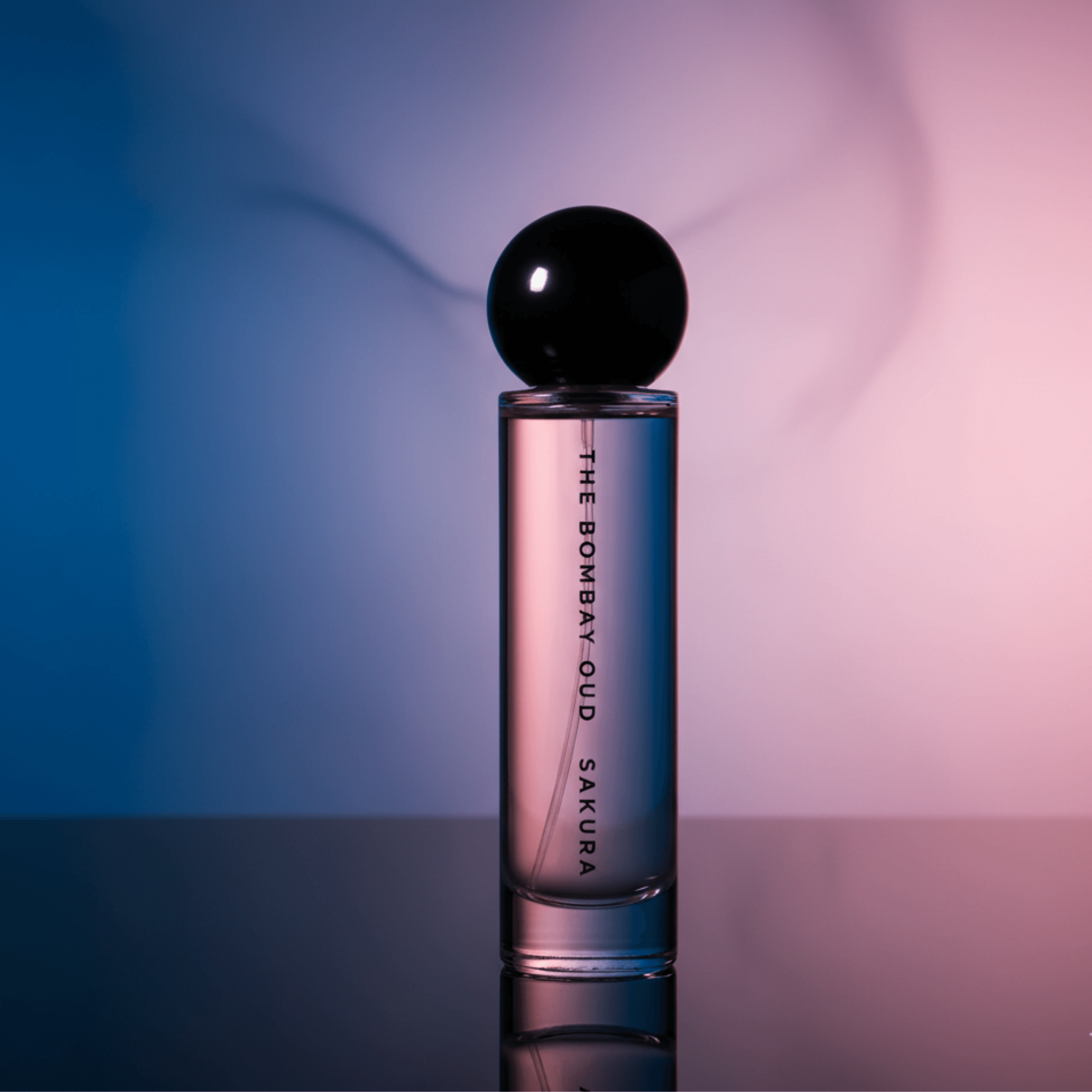 sakura 60ml perfume bottle lit with moody pink and blue lighting, showcasing its luxurious and serene aesthetic for premium fragrance buyers.
