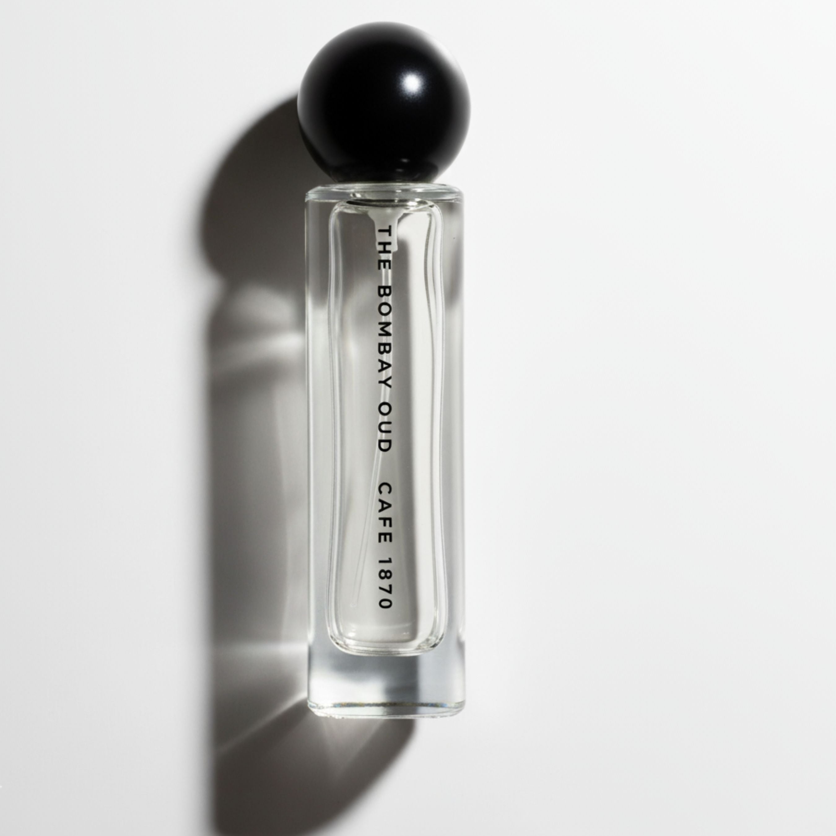 Cafe 1870 60ml perfume bottle by The Bombay Oud with minimalist design and black spherical cap, ideal for personal fragrance collections.