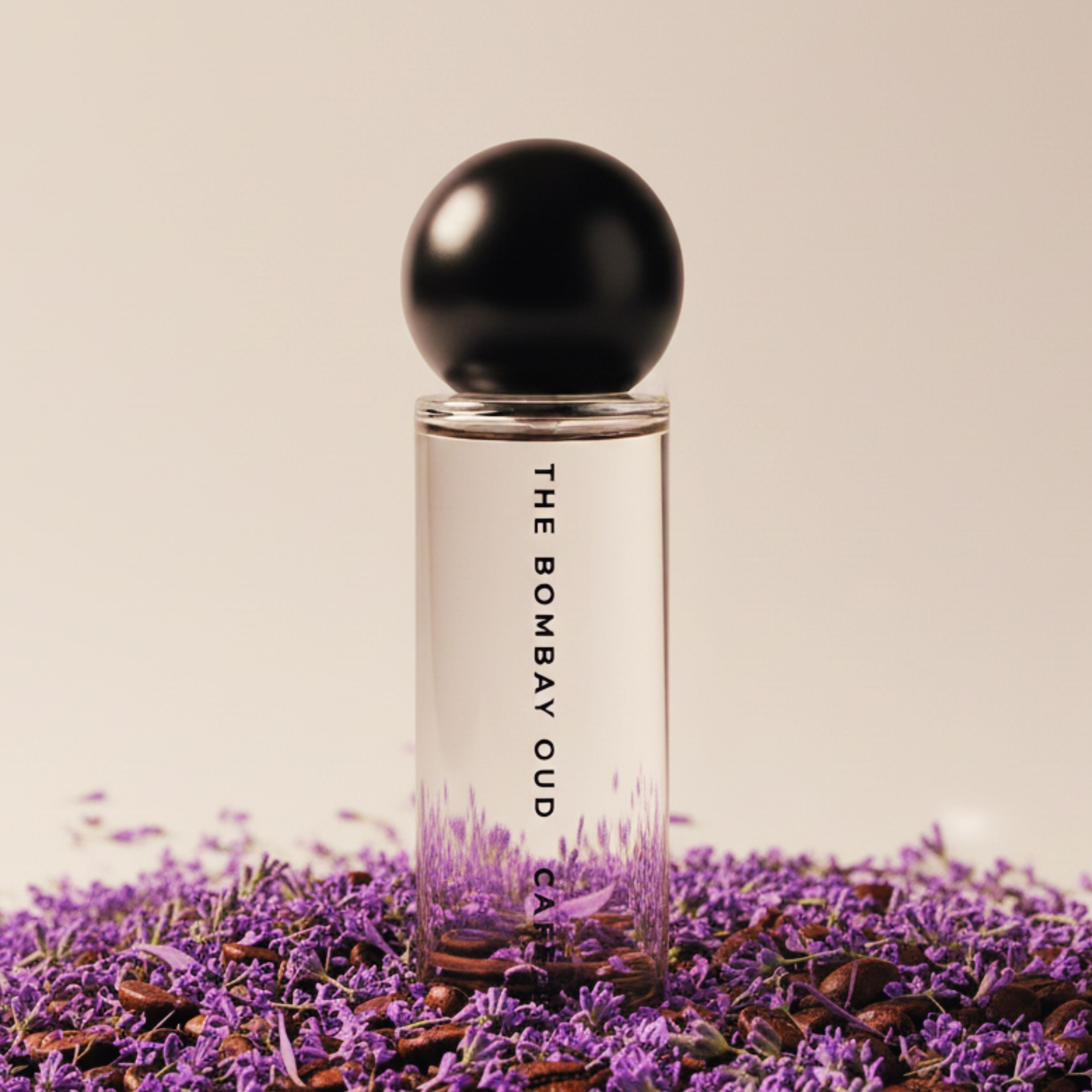 Cafe 1870 60ml perfume by The Bombay Oud placed on lavender and coffee beans, highlighting its warm, aromatic scent profile.