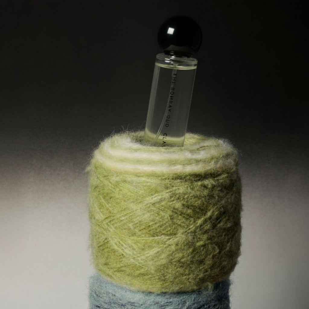 Classic 60ml fragrance by The Bombay Oud nestled in soft green and blue wool, evoking the scent’s calming and spa-like essence.