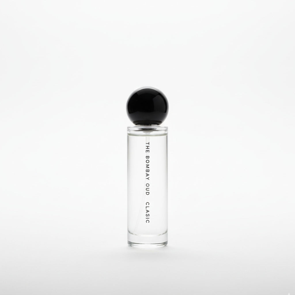 Minimalist product shot of Classic 60ml by The Bombay Oud, featuring a clear glass bottle with black spherical cap on a white background.