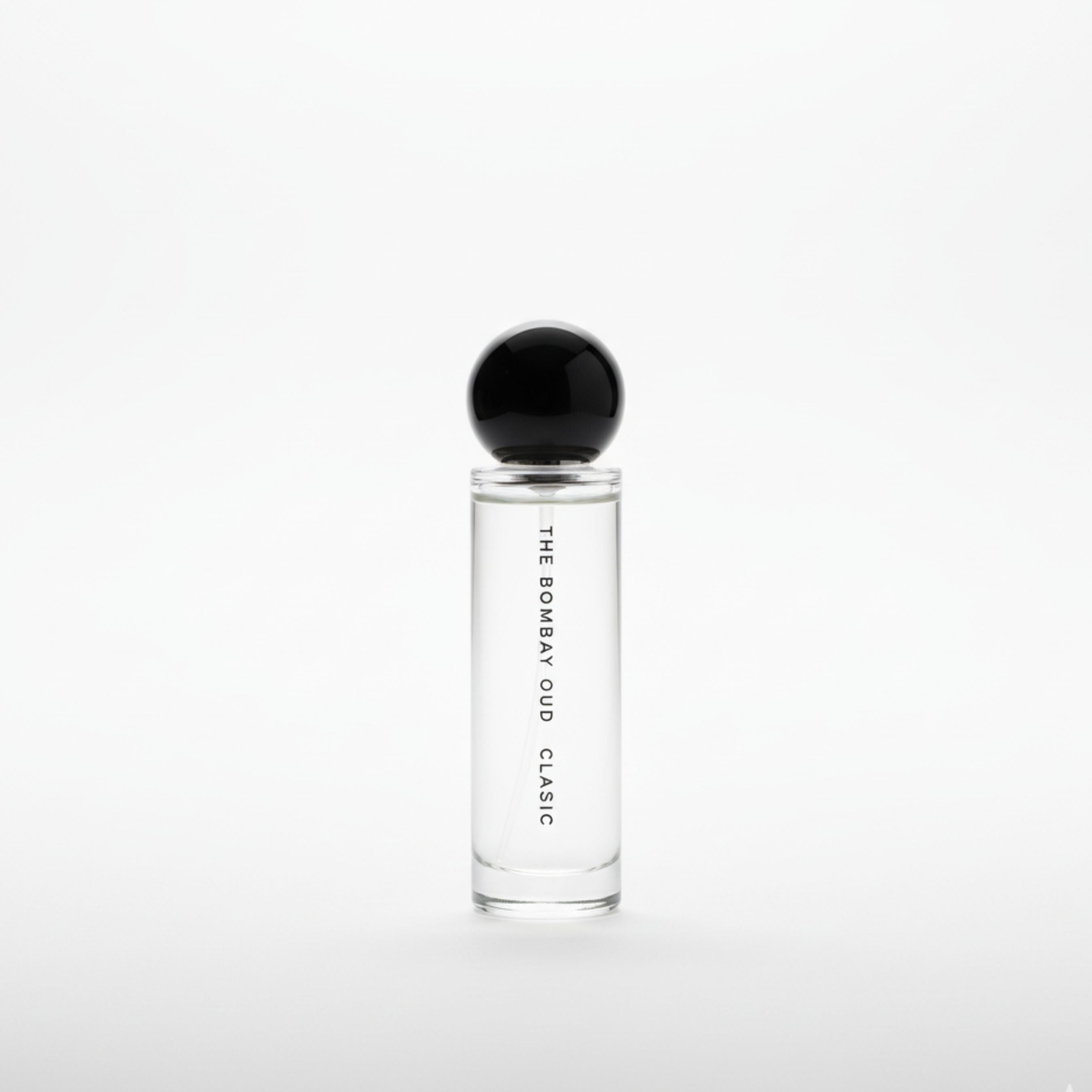Minimalist product shot of Classic 60ml by The Bombay Oud, featuring a clear glass bottle with black spherical cap on a white background.