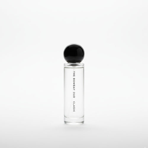 Minimalist product shot of Classic 60ml by The Bombay Oud, featuring a clear glass bottle with black spherical cap on a white background.