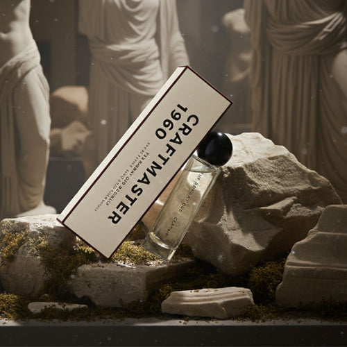 Classic 60ml by The Bombay Oud displayed among ancient ruins and statues, paired with Craftmaster 1960 packaging for a timeless aesthetic.