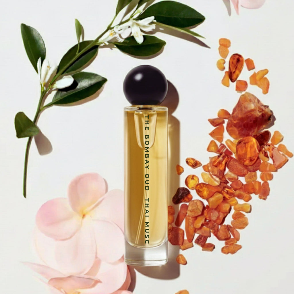 Thai Musc 60ml perfume bottle styled with amber resin, white florals, and pink petals, highlighting its musky floral scent profile.